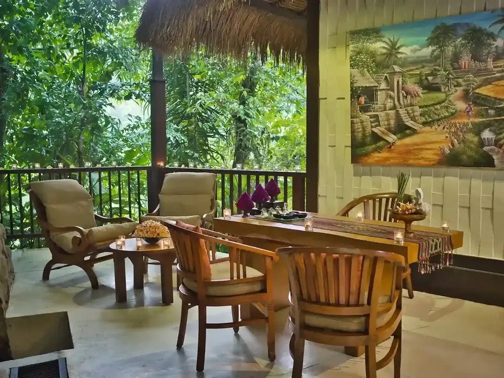 An open-air wooden pavilion with armchairs and a table looking out over the jungle near Ubud, Bali